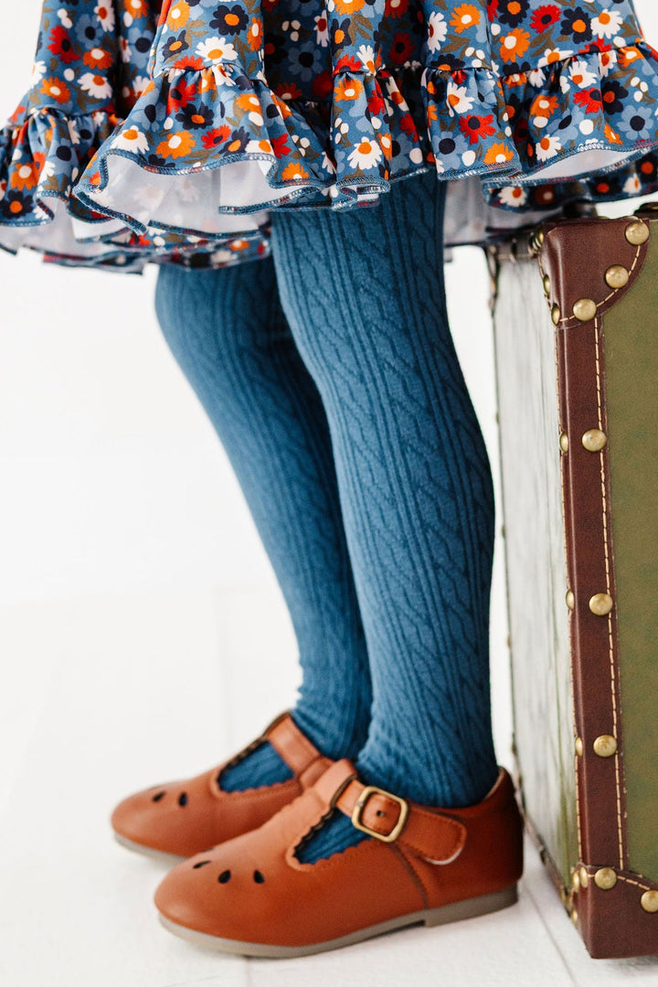 girl wearing blue cable knit tights with blue floral print dress