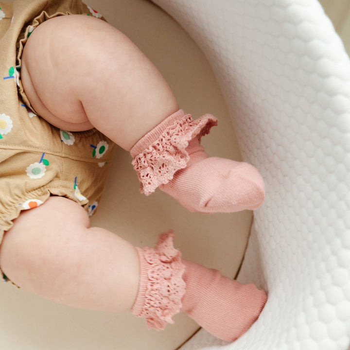 baby girl wearing blush pink lace midi socks