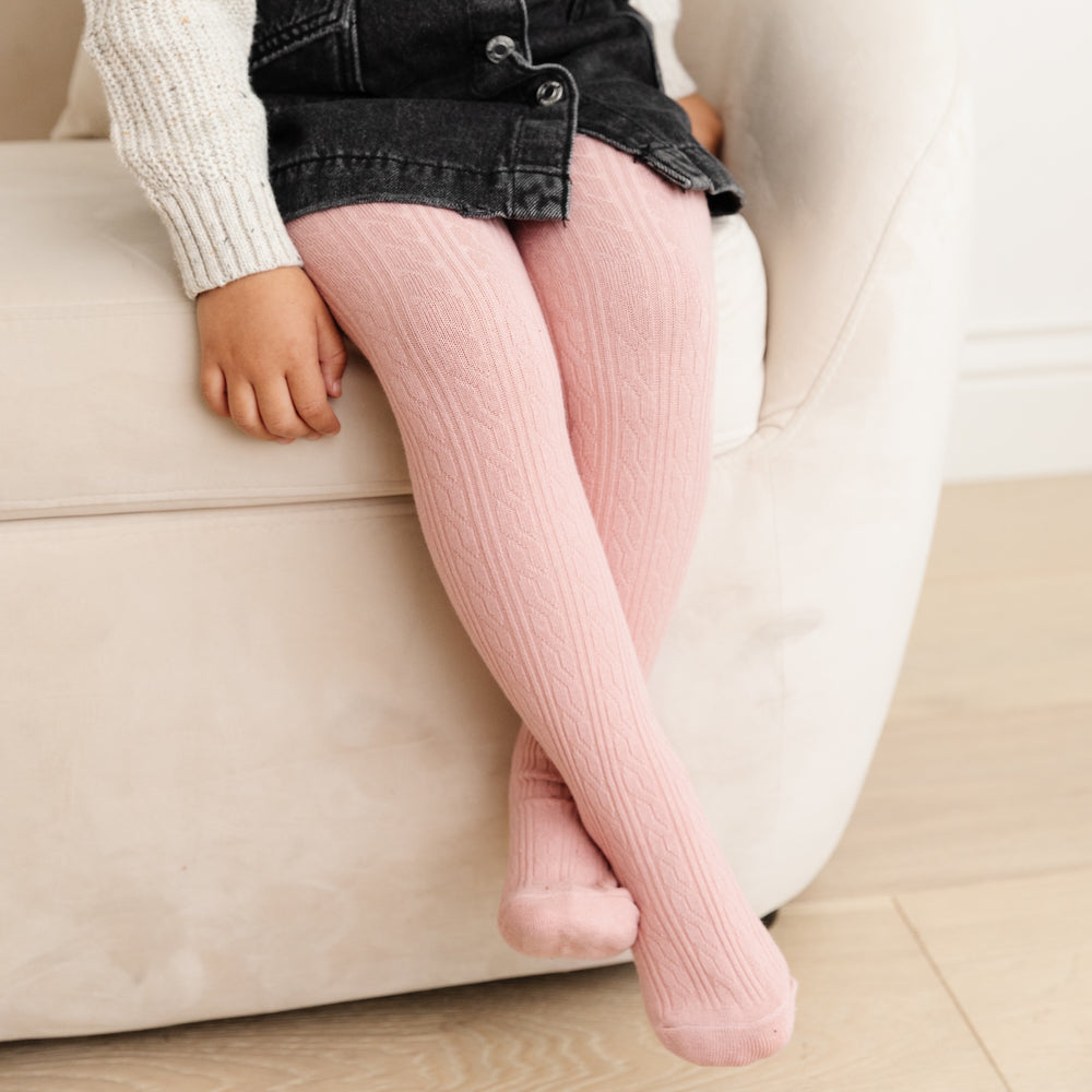 blush pink cable knit tights on little girl sitting on couch