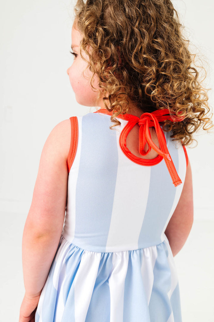 detail photo of little girl in blue and white wide stripes tank twirl with orange trim and keyhole tie back