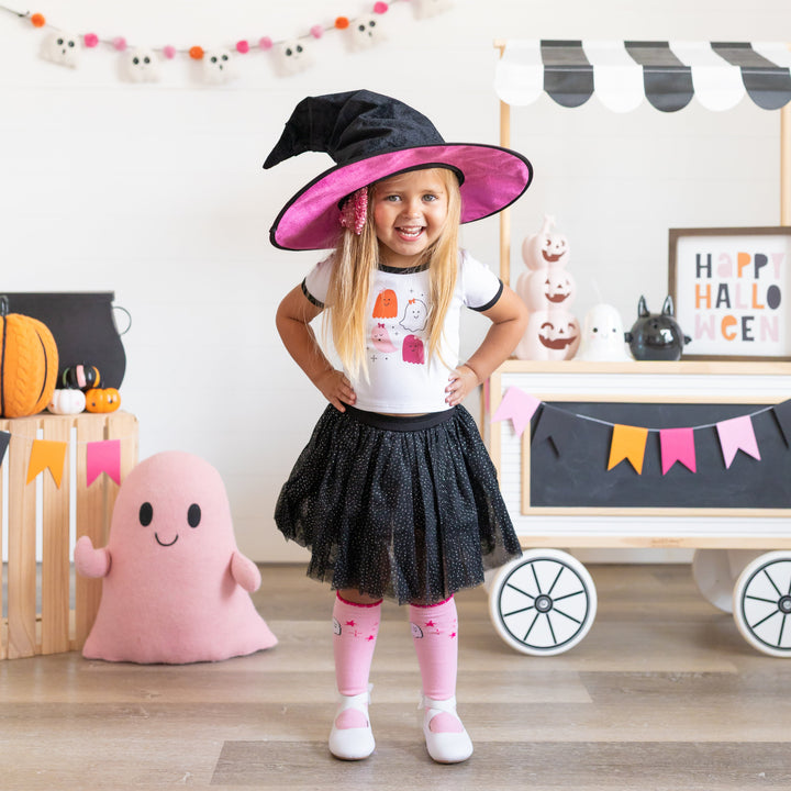 little girl in witch hat, white ghost tee with black binding, sparkly black tutu skirt with built in shorts and matching pink ghost knee socks for Halloween