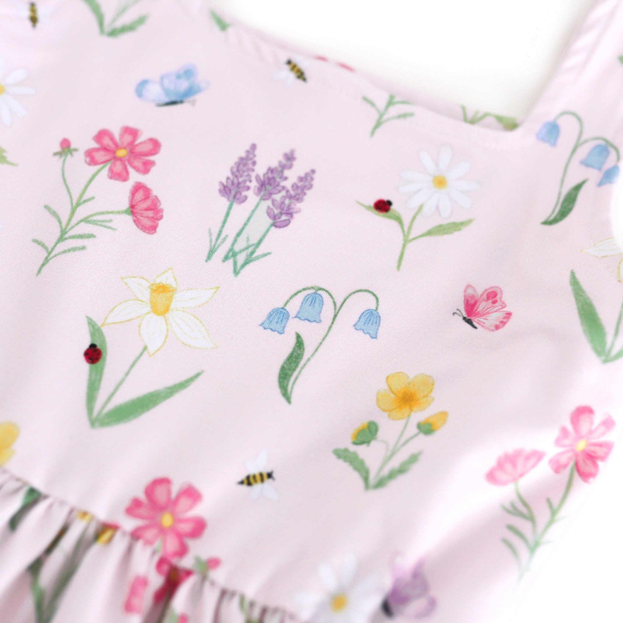 closeup of girls' botanical floral print twirl dress with lady bugs, butterflies and bees