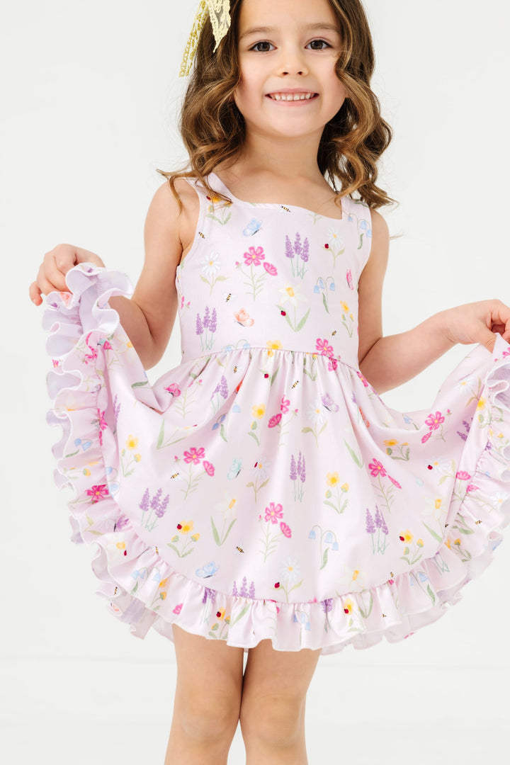 little girl posing in pretty botanical floral print tank twirl dress with ruffle hem and square neckline