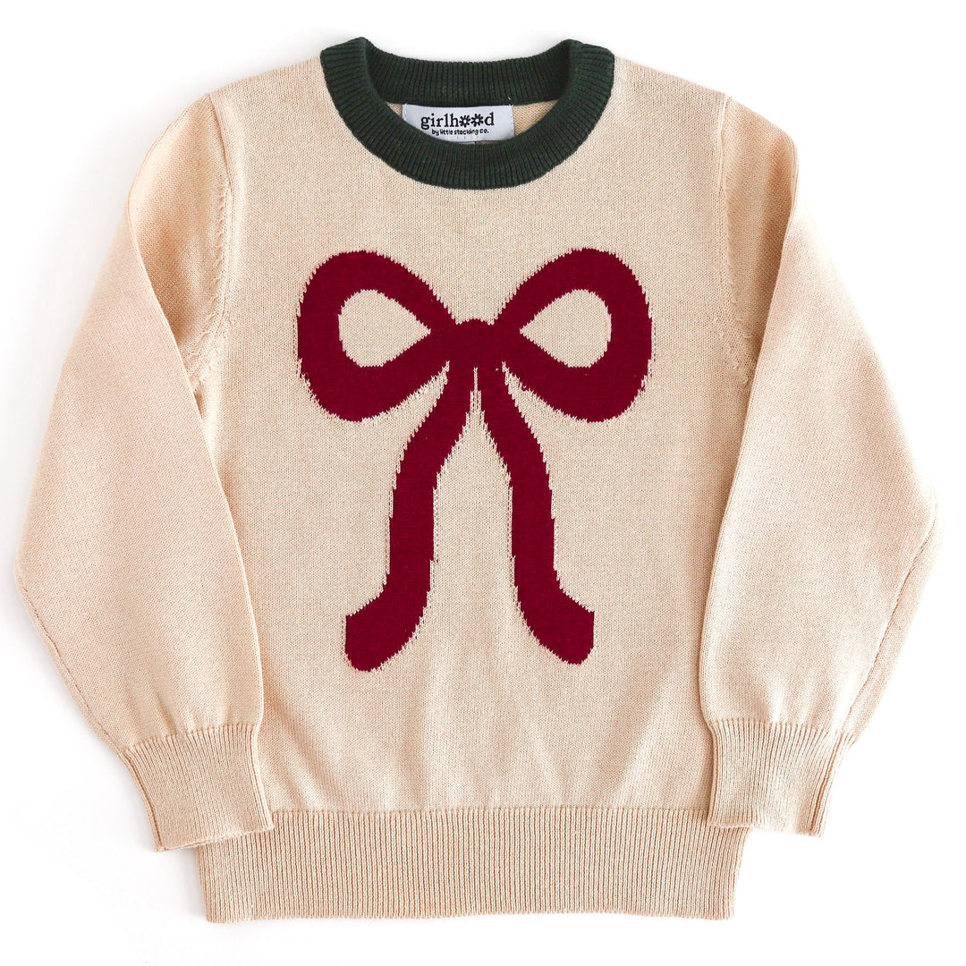 girls cream Christmas sweater with forest green trim at the neckline and large crimson ribbon design 