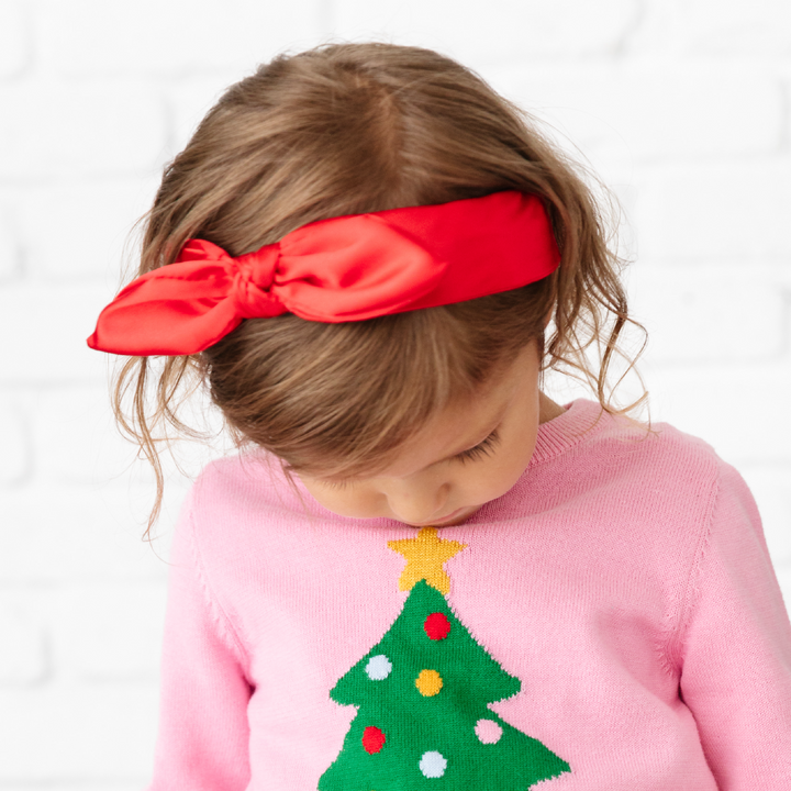 little girl in bright red satin headband for Christmas