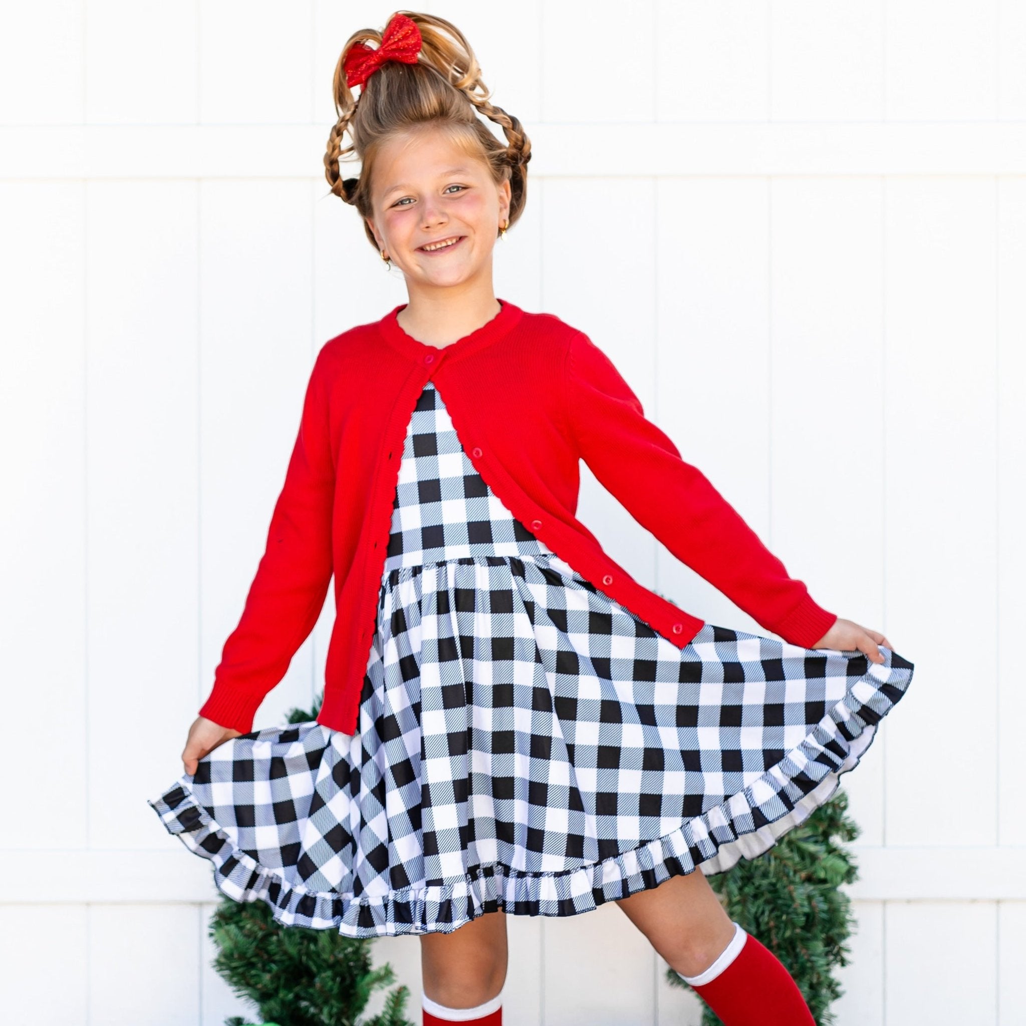 little girl in bright red Christmas and black and white buffalo plaid dress