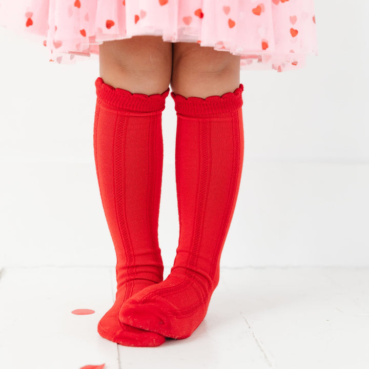 little girl in red scallop trimmed knee highs with vertical knit detail and matching tutu dress with hearts