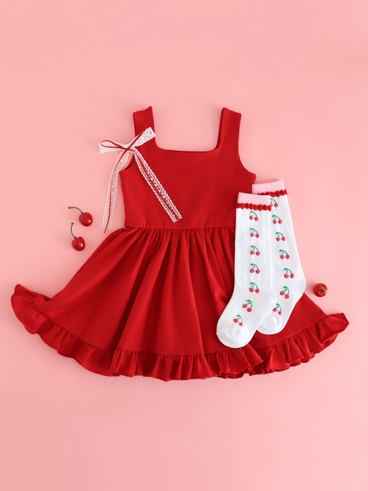 girls' bright red sleeveless twirl dress styled with cherry patterned knee high socks and white lace with red ribbon double hair bow