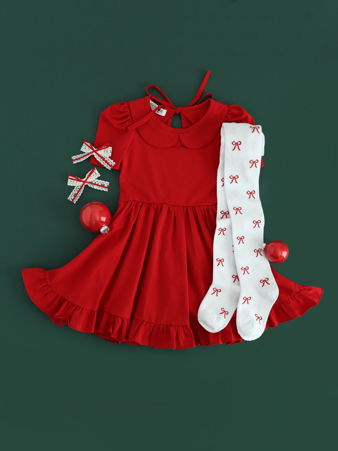 girls red Christmas twirl dress paired with white bow tights and white lace pigtail bows with dainty red ribbon