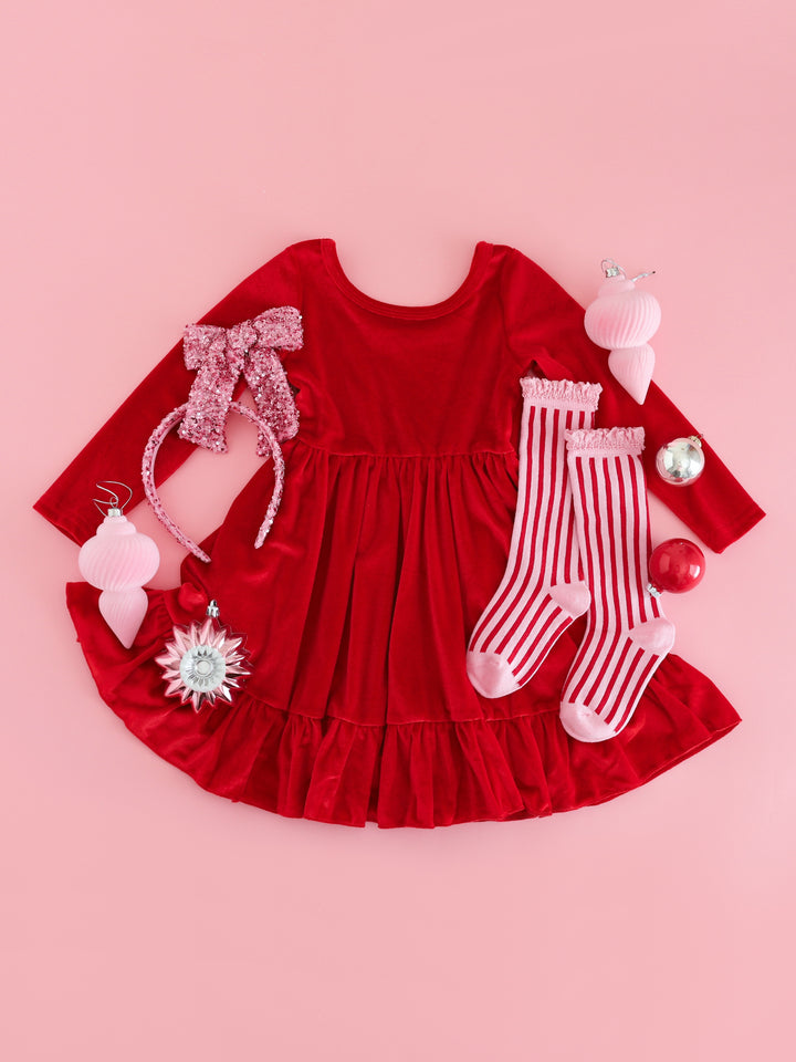 girls' red velvet long sleeve twirl dress with sparkly pink hair accessories and red and pink striped knee socks for Christmas