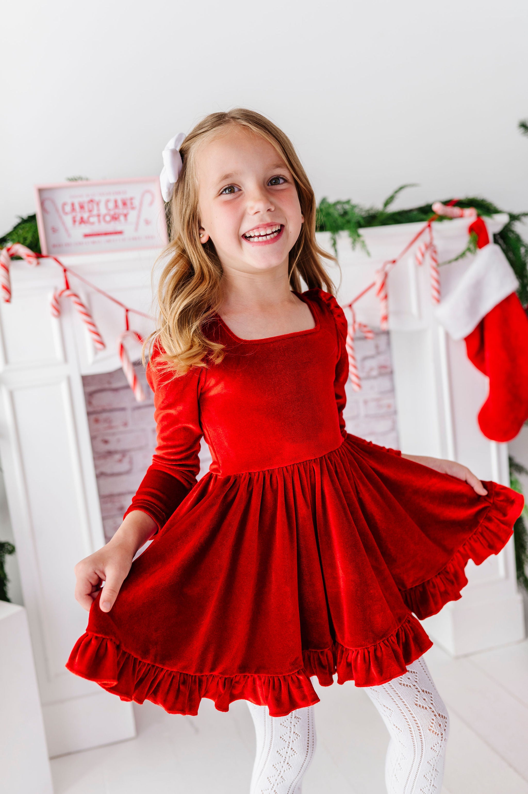 girl wearing bright red velvet dress with square neckline and ruffled twirl skirt