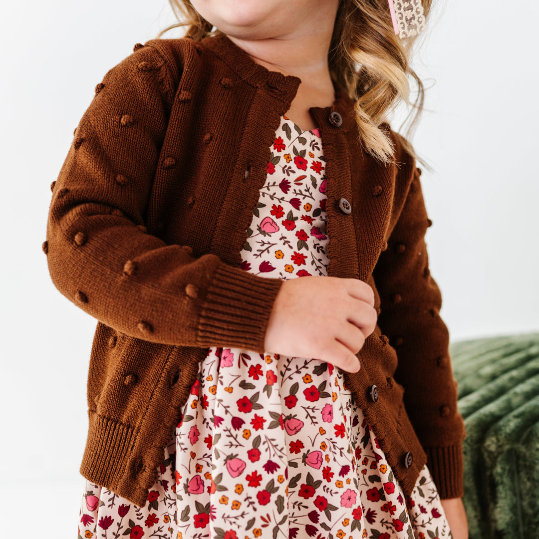 little girl in fall floral dress and brown knit cardigan with 3D bubble textrue