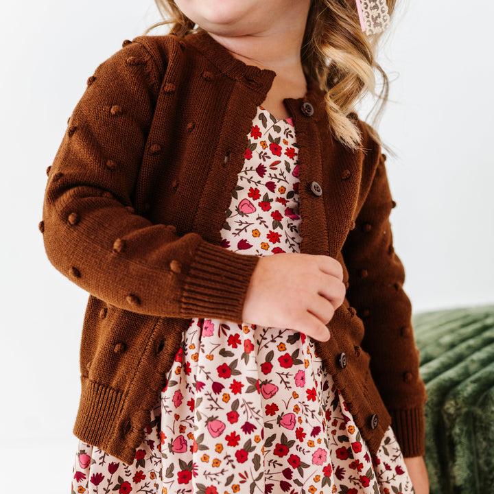 little girl in fall floral dress and brown knit cardigan with 3D bubble textrue