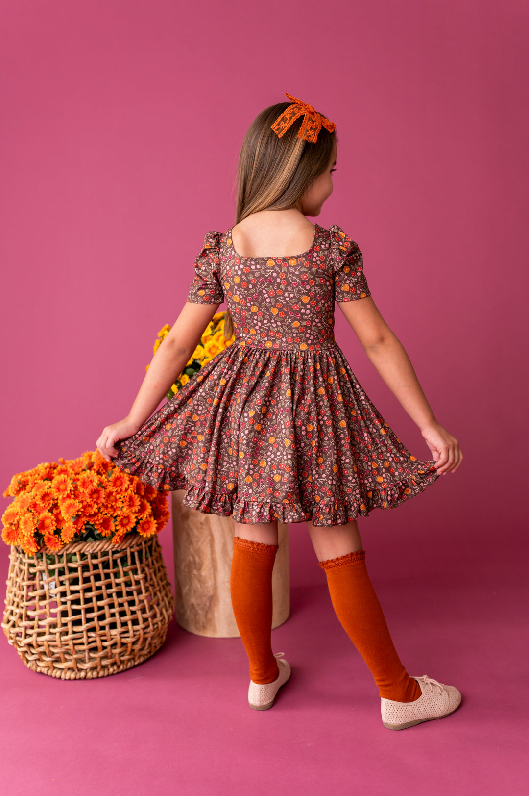 little girl in brown fall floral square neck twirl dress paired with pumpkin spice accessories