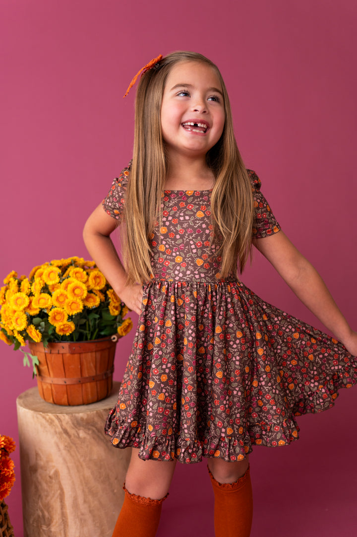 young girl in brown fall floral square neck twirl dress paired with knee socks and bow in pumpkin spice
