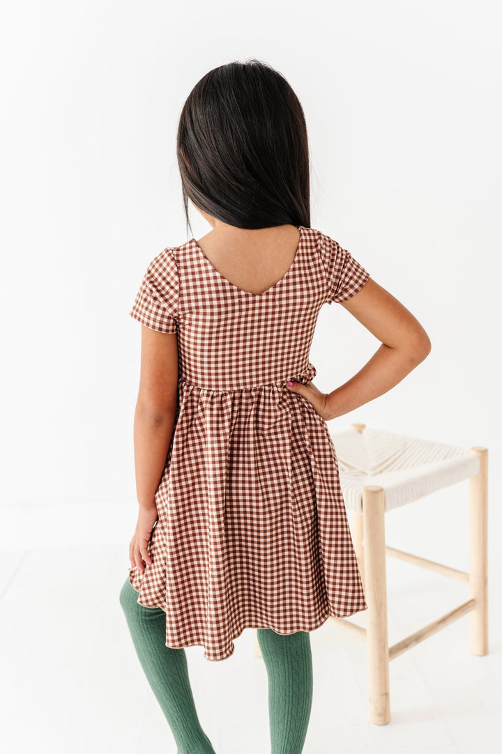 back view of v-neck twirl dress in brown gingham paired with blue-green fall tights