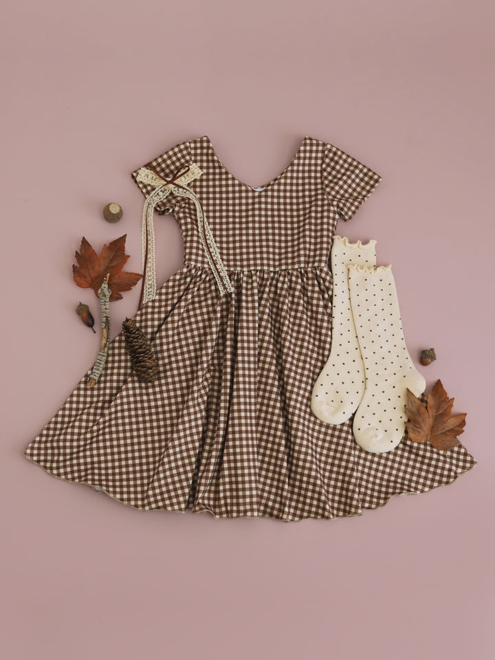 girls' two-tone brown v-neck twirl dress paired with cream polkaditted knee socks and cream and brown lace ribbon hair bow