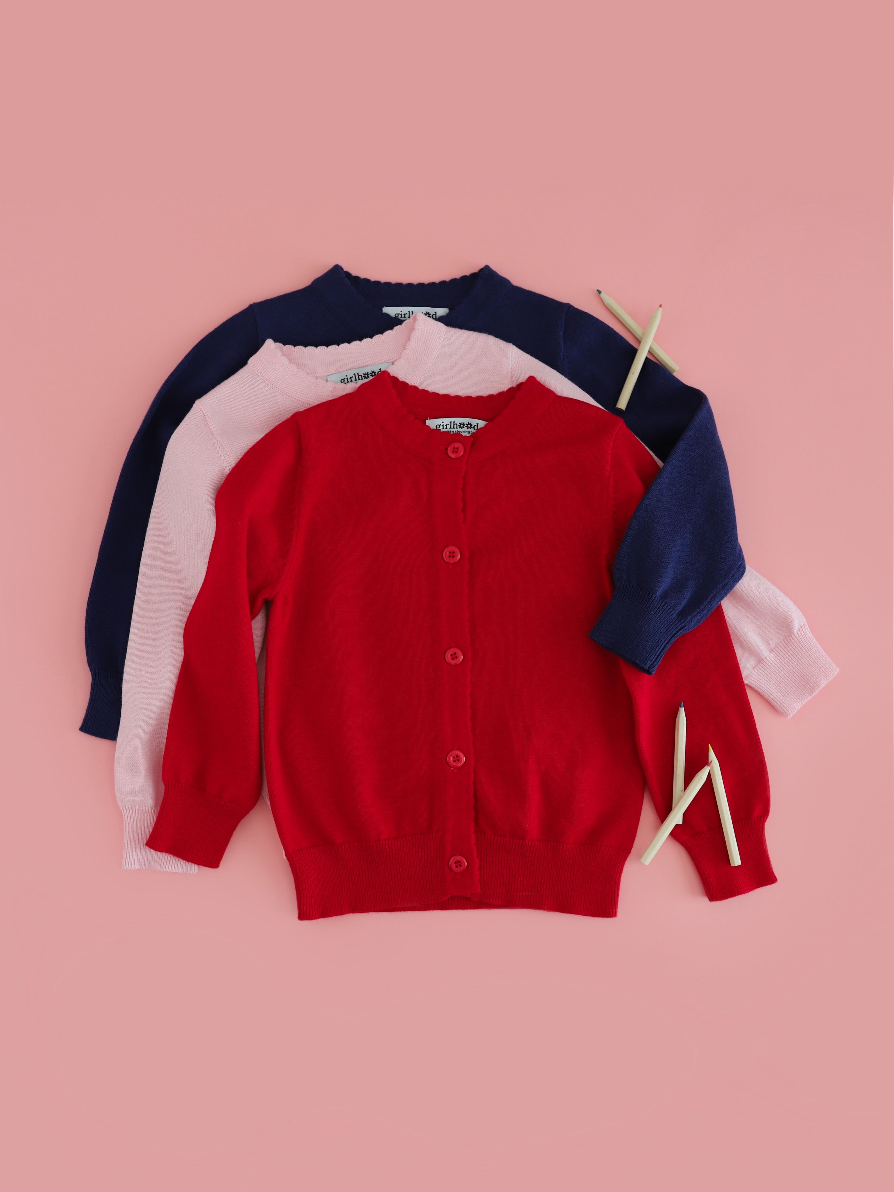 trio of girl's cotton knit button up cardigans in navy, pink and red to match school outfits and uniforms