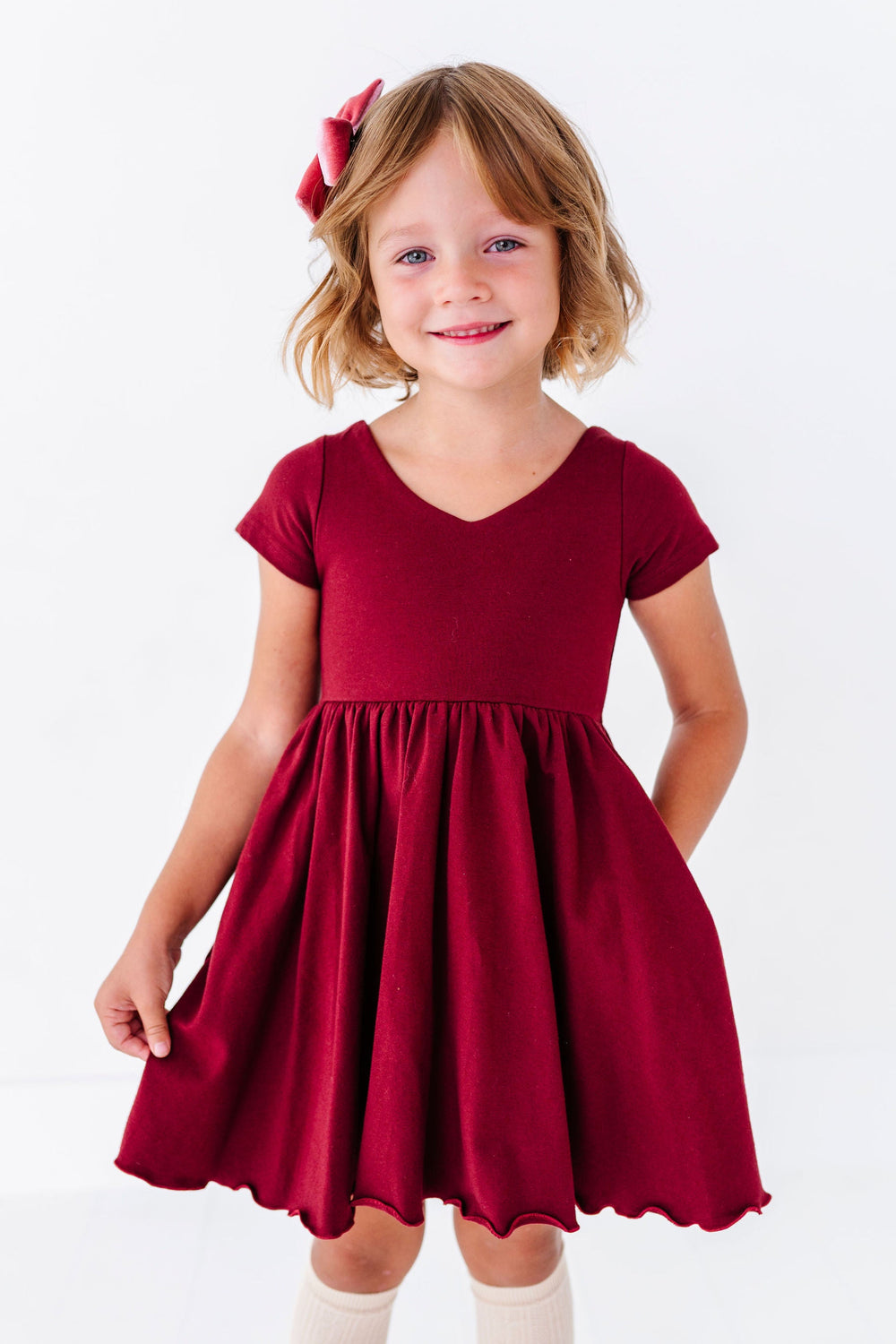 girl wearing burgundy v neck twirl dress