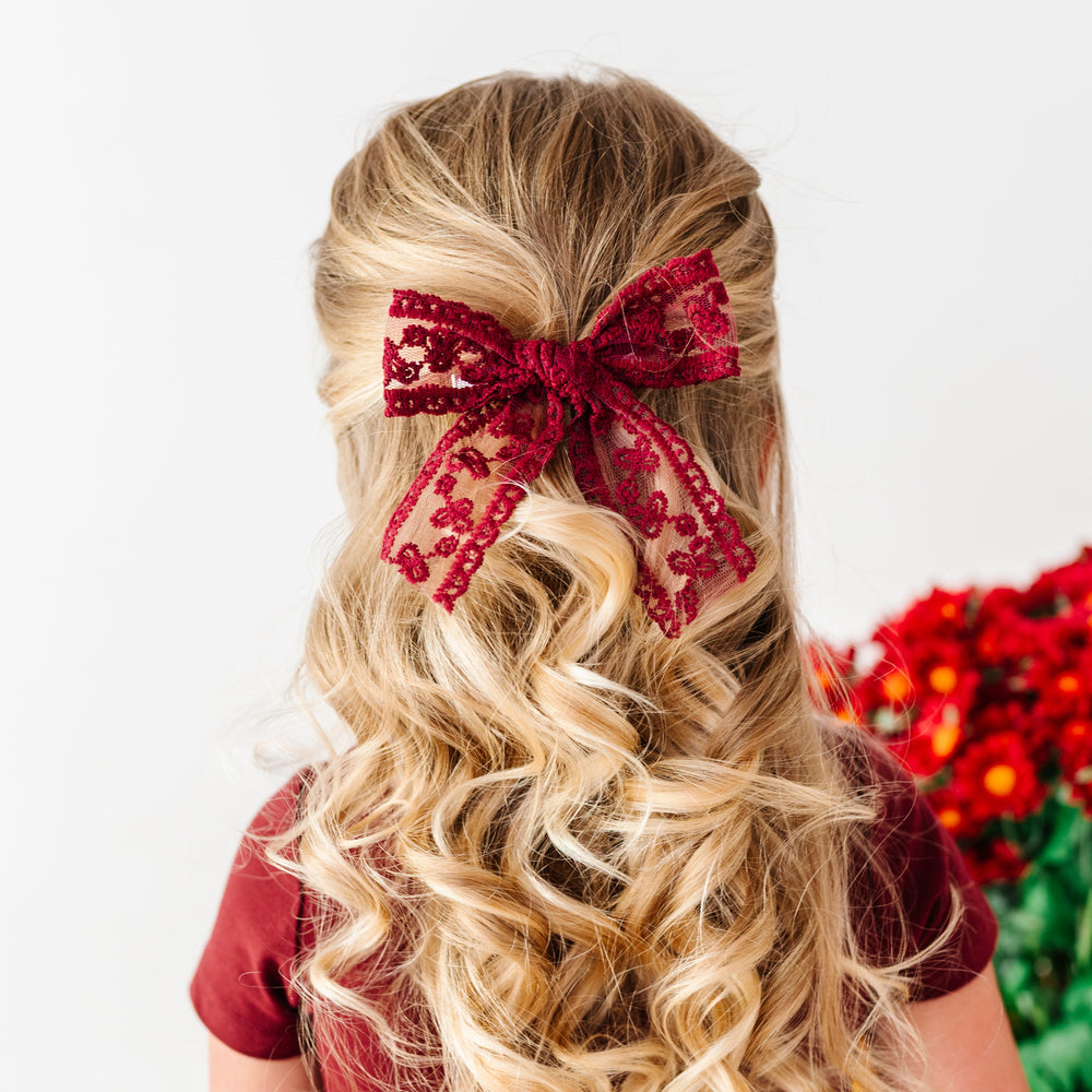 girl in burgundy fall dress and matching lace burgundy hair bow on clip