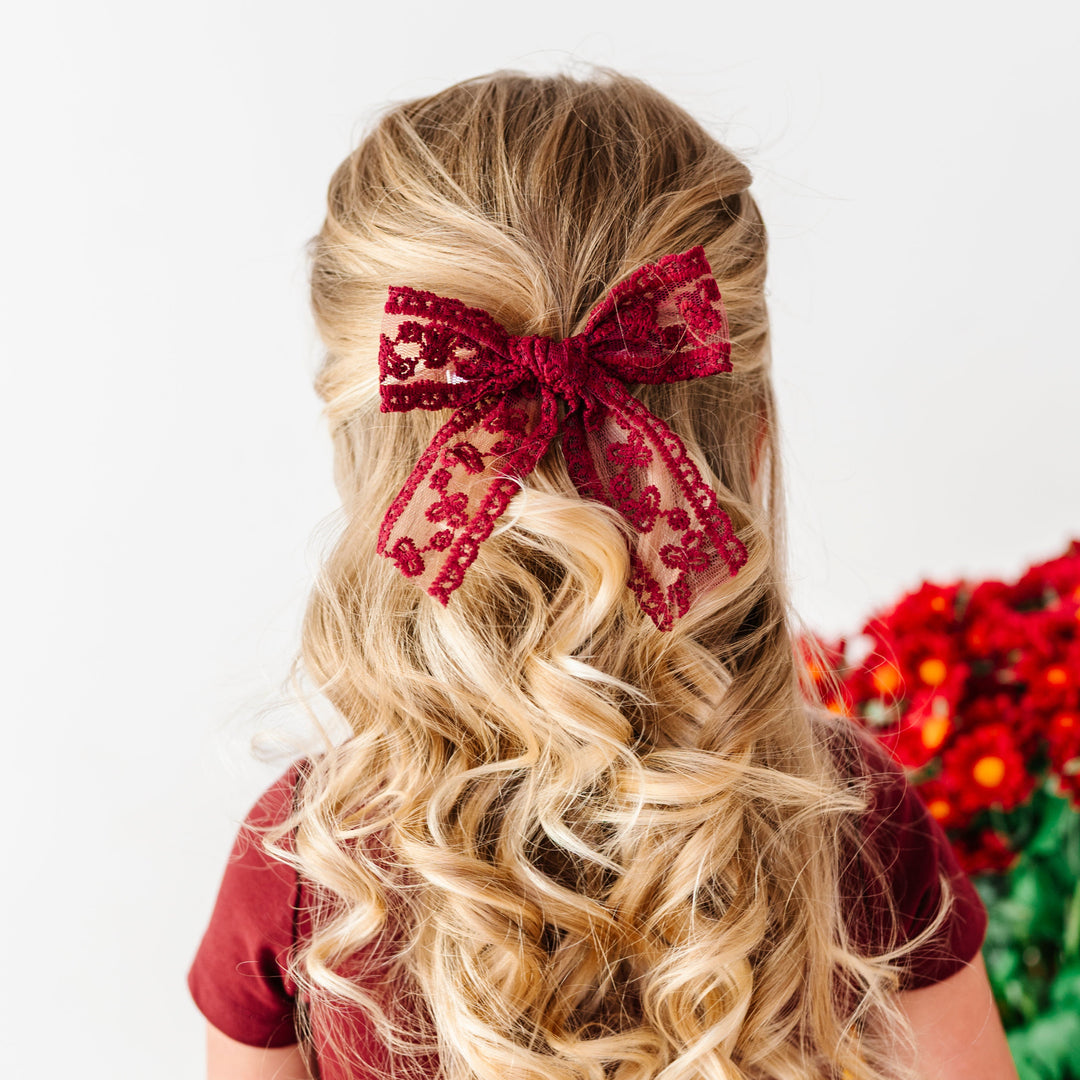 girl in burgundy fall dress and matching lace burgundy hair bow on clip