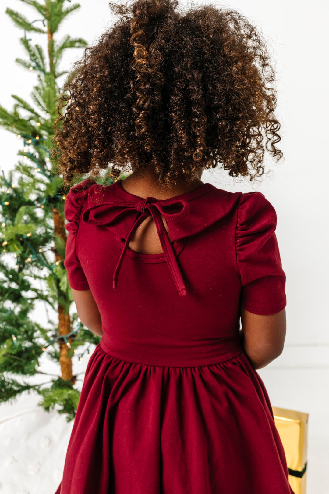 little girl in tie back, short sleeve, collared twirl dress styled for Christmas 