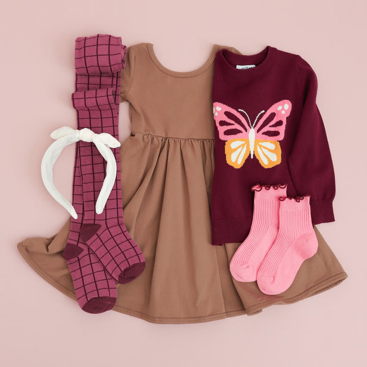 flatlay of girls mocha dress, butterfly pullover sweater, mulberry grid tights, pink lettuce trim sock and ivory velvet headband