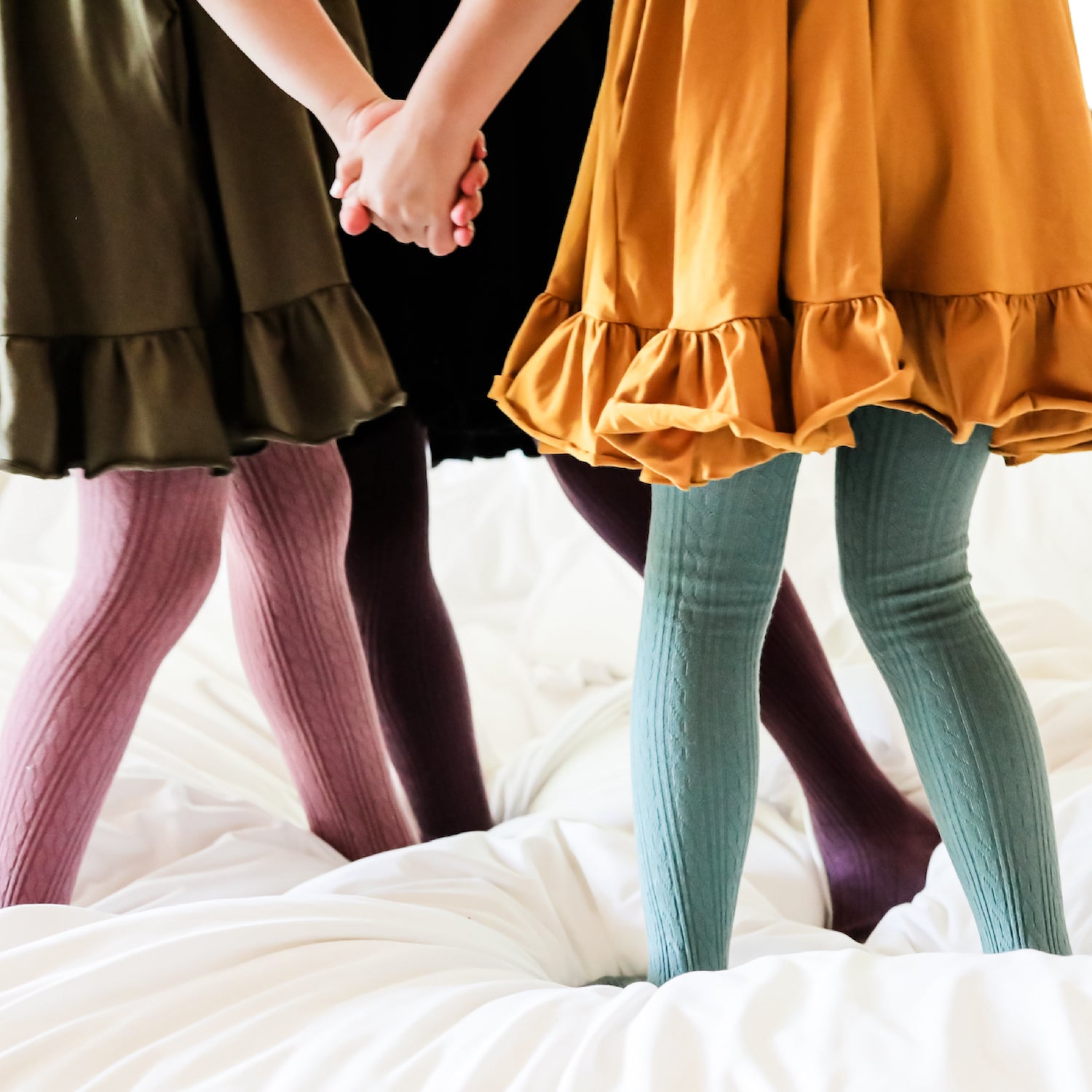 girls standing on bed in fall cable knit tights