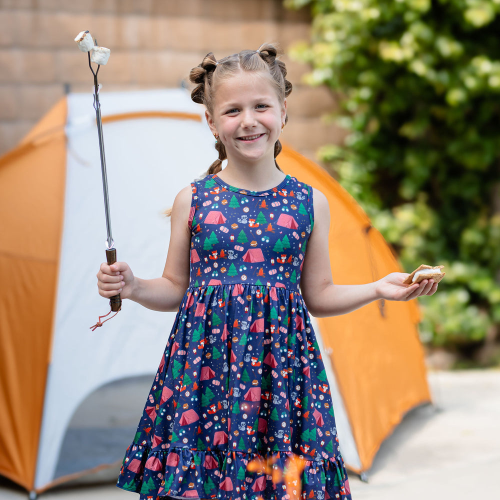 little girl wearing camping themed dress making smores