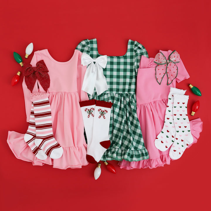 little girls pink and green Christmas dresses with matching Candy Cane Lane inspired knee highs and bows