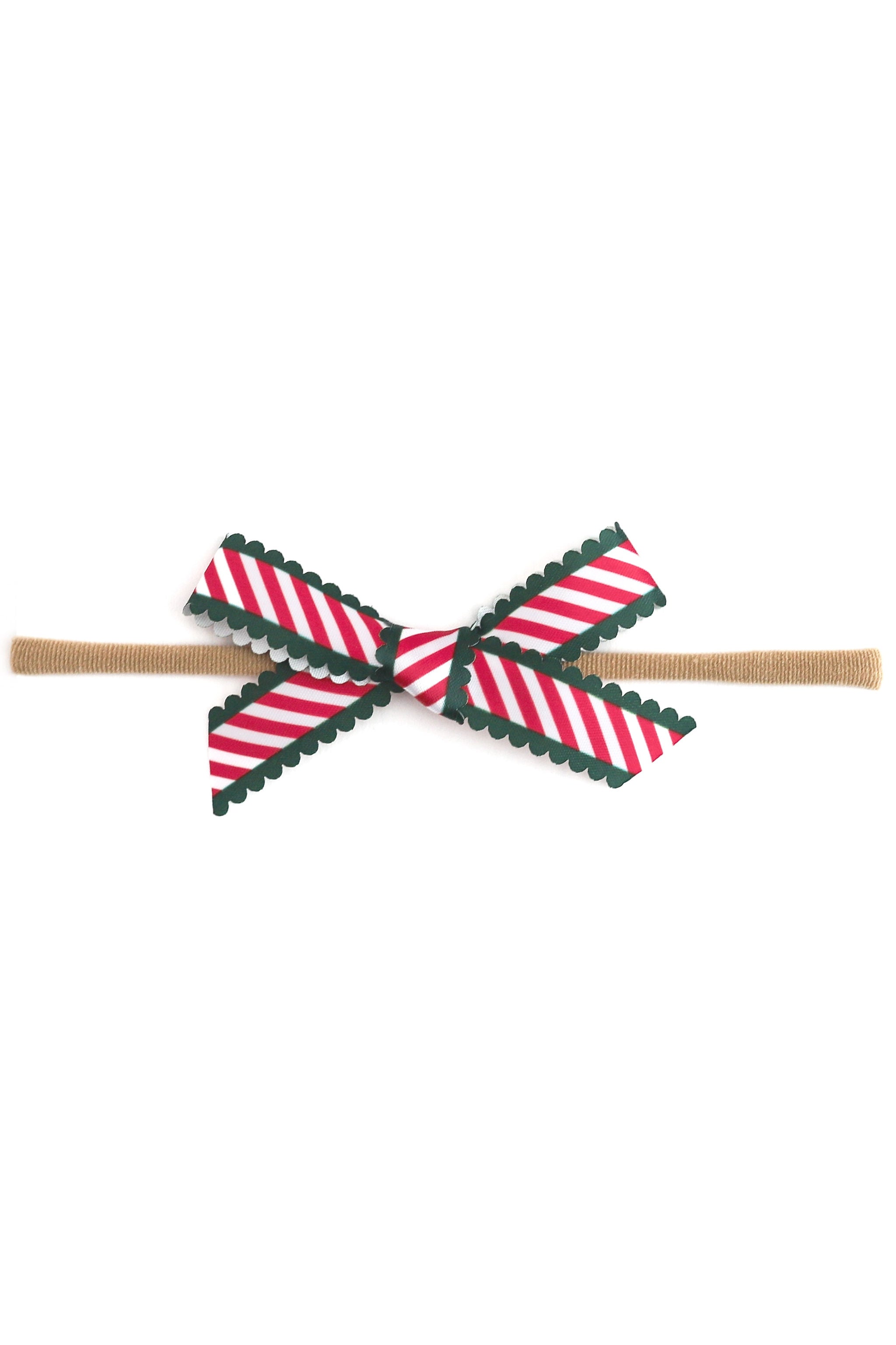 photo of printed scallop ribbon baby bow in candy cane stripes with green scallop trim on nylon headband on white background