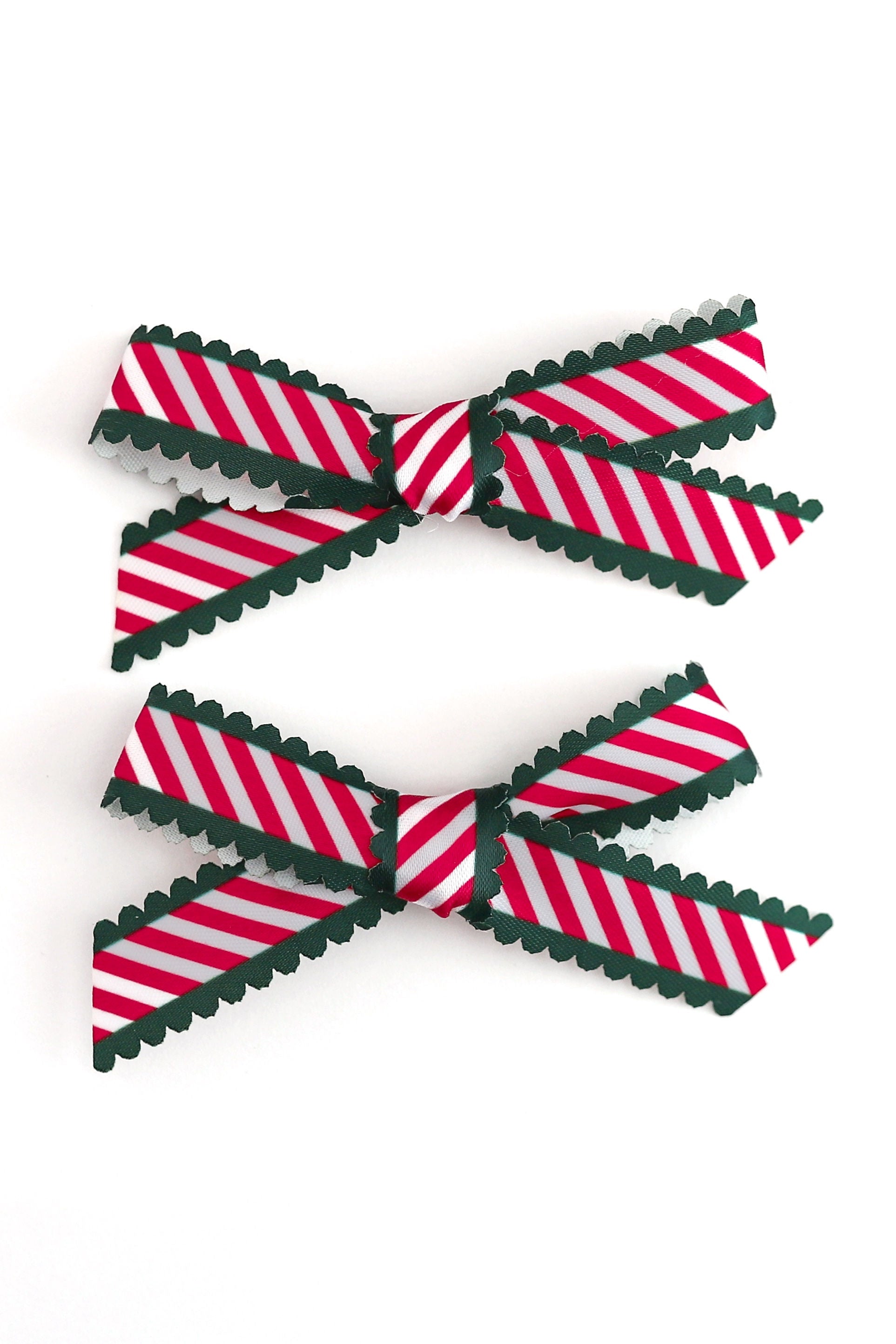 candy cane stripe ribbon pigtail bows with green scalloped edges shown on white background