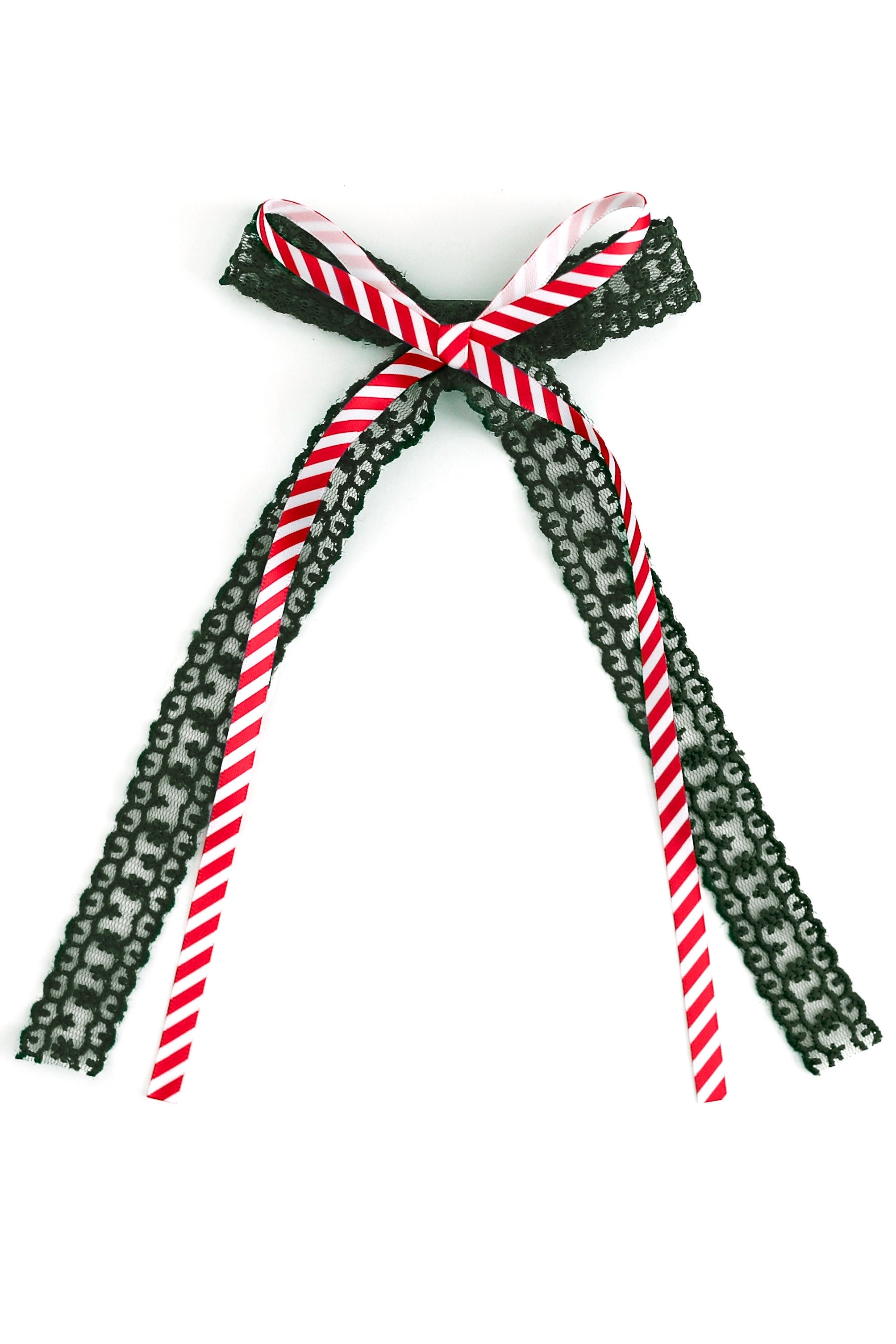 christmas hair bow with dark green lace and printed candy cane stripe ribbon on top shown on white background