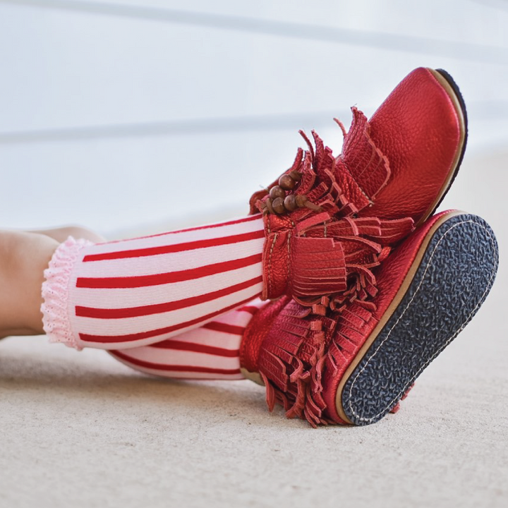 little girl in pink with red stripe candy cane knee highs and red leather shoes