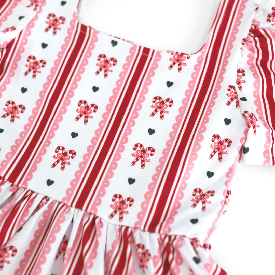 closeup of white twirl dress bodice with vintage inspired candy cane wallpaper print for Christmas