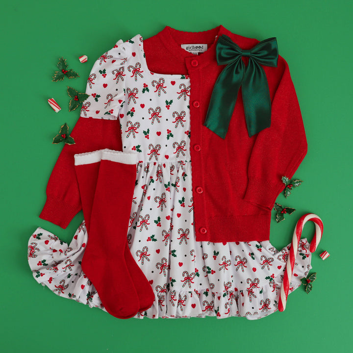 little girls candy cane themed Chrismas outfit with matching red sparkle knit cardigan, red and white knee highs and green satin bow