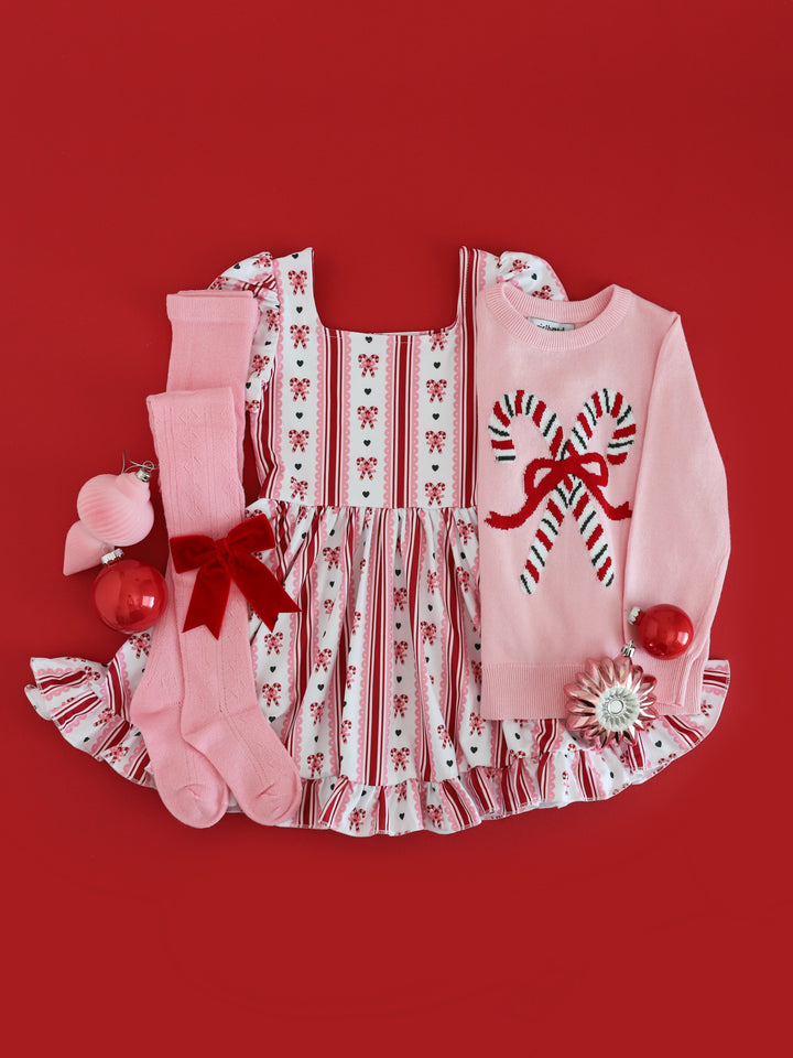 girls vintage candy cane twirl dress paired with pink candy cane sweater, pink tights and red velvet bow for Christmas