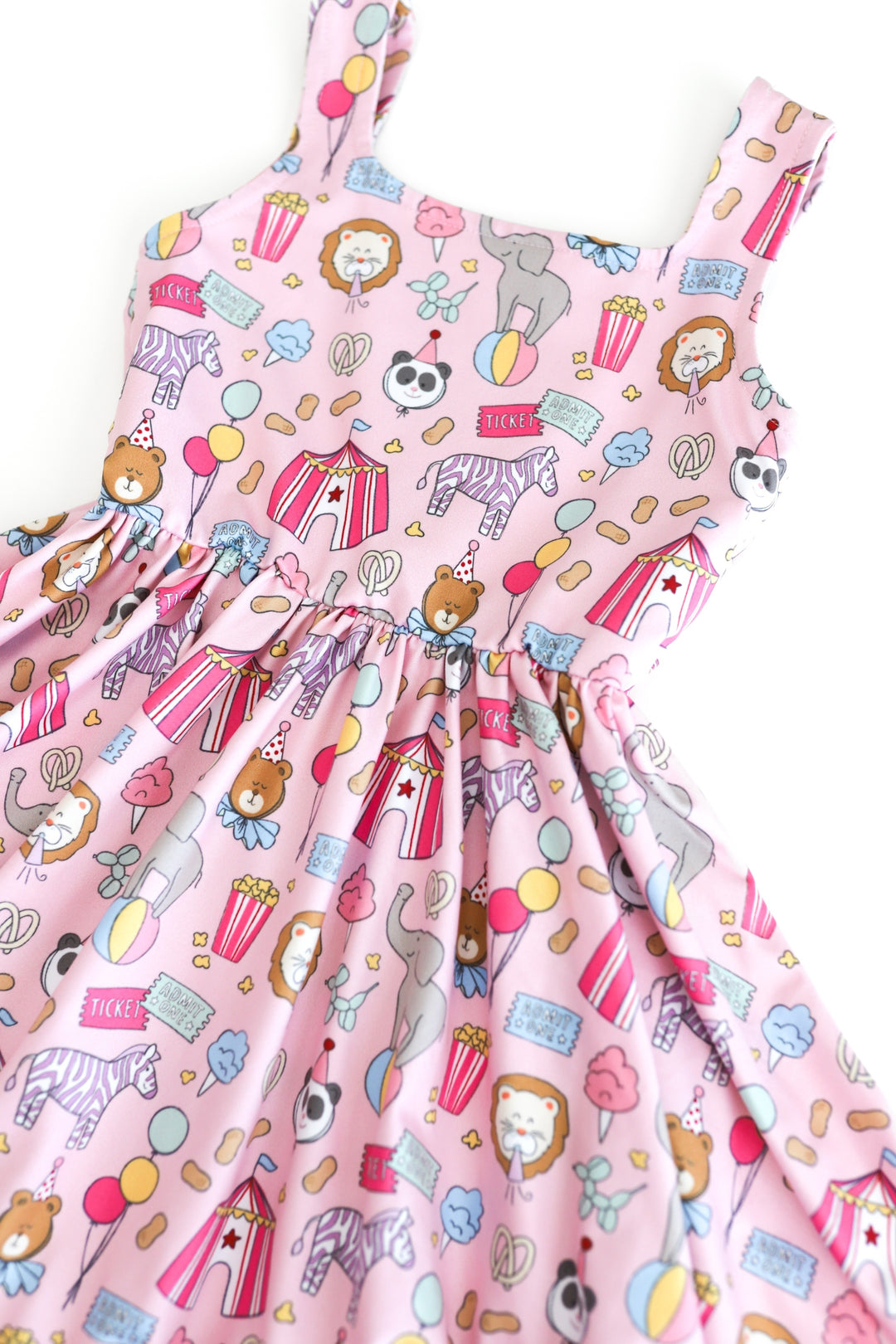 detail photo of girls' pink sleeveless twirl dress with carnival themed print featuring square neckline and ruffle hem