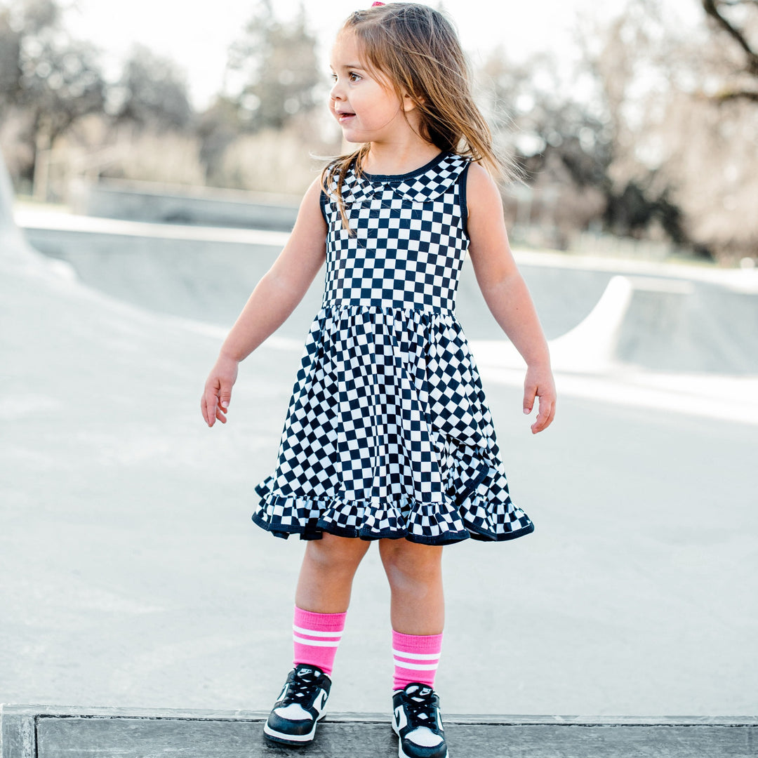 little girl at skate pakr wearing black and white checkered tank top twirl dress with pockets