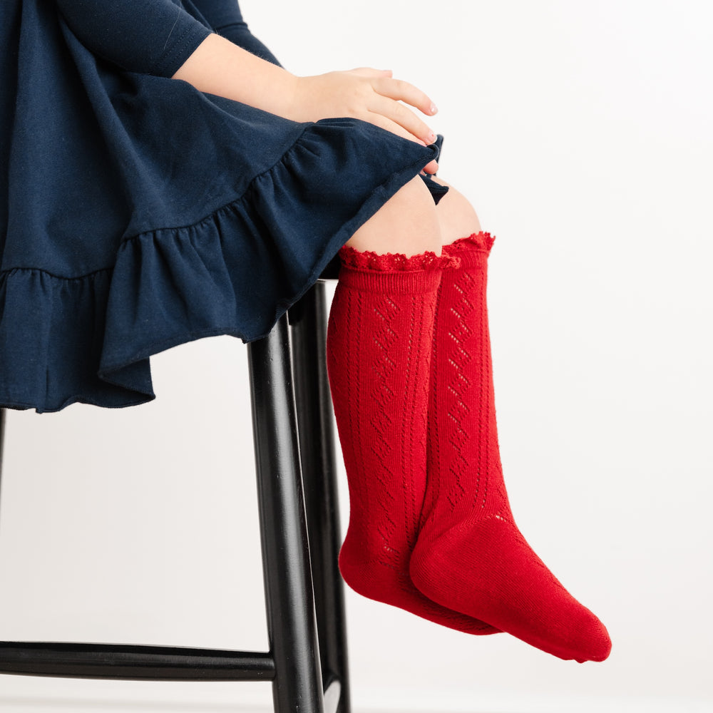 cherry red fancy open knit crochet knee high socks on little girl in navy blue twirl dress