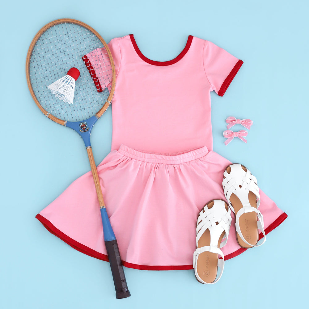 girls pink cotton blend charm t-shirt with red binding paired with matching pink with red trim skirt with built in shorts for summer