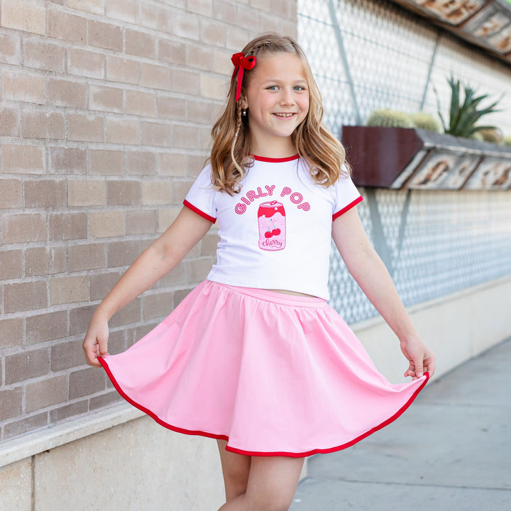 little girl in "girly pop" design tee and coordinating pink skort with red binding and built in bloomers for girly summer vibes