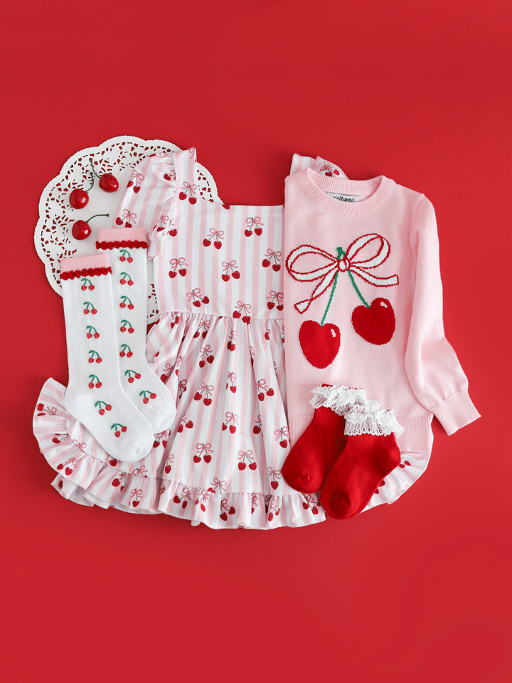 girls cherry themed outfit with cherry print twirl dress, knit sweater, knee high socks and coordinating red with white lace bobby socks