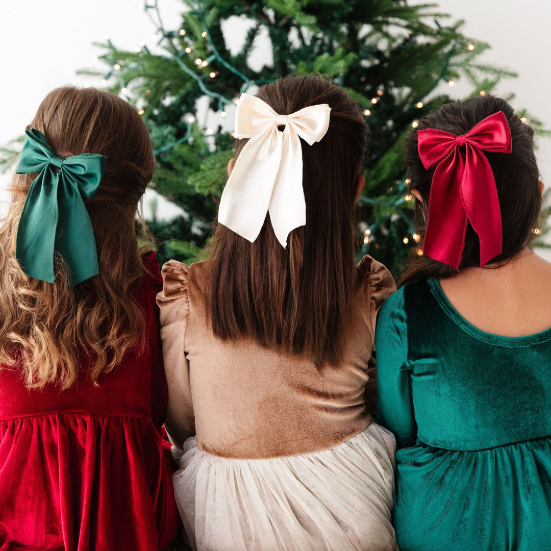 girls wearing christmas party dresses with matching satin hair bows