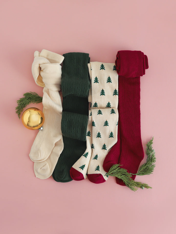 four pairs of girls' Christmas tights in cream, forest, crimson and cream with christmas trees