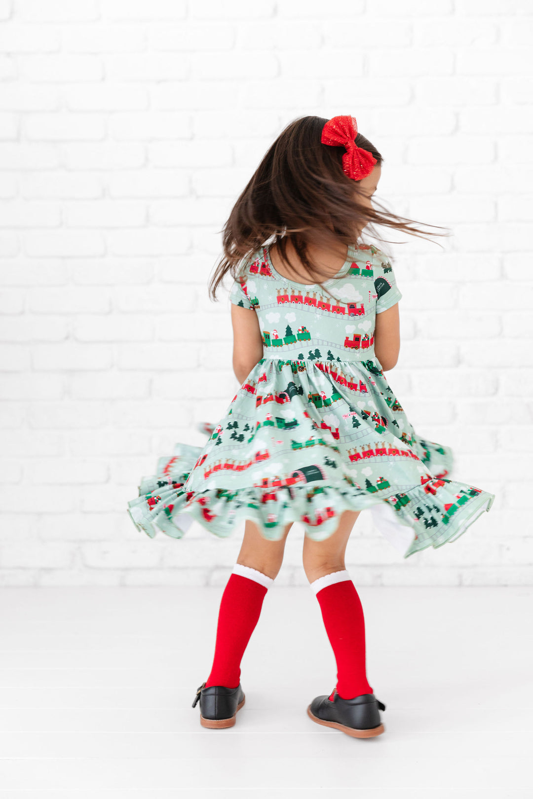 girl twirling in christmas train dress