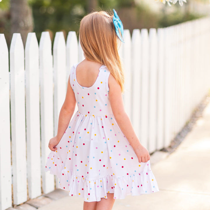 back detail of circus dot dress on little girl walking outside