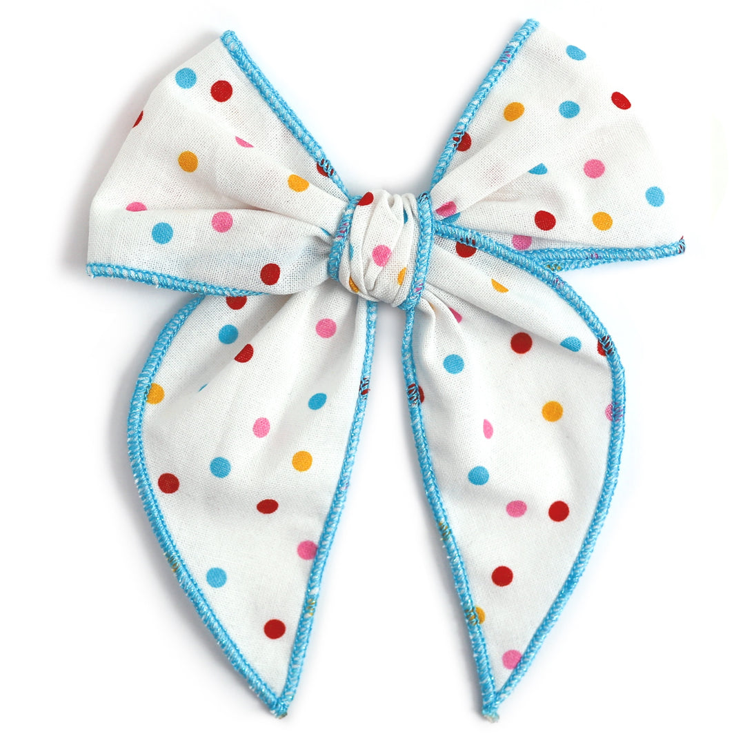 white girls hair bow with rainbow polka dots and aqua blue trim