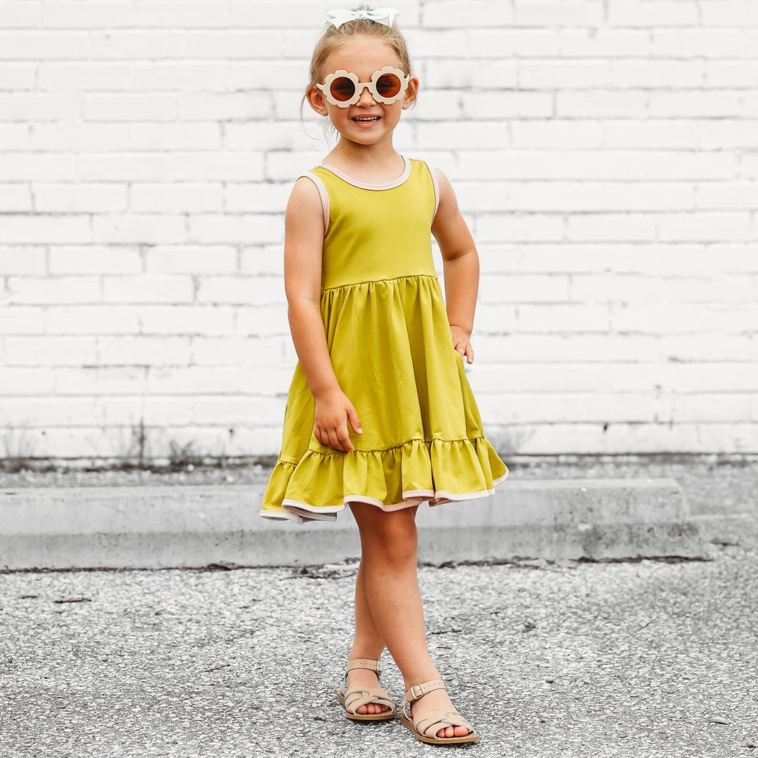 little girl in citron and blush tank dress and flower shaped sunglasses