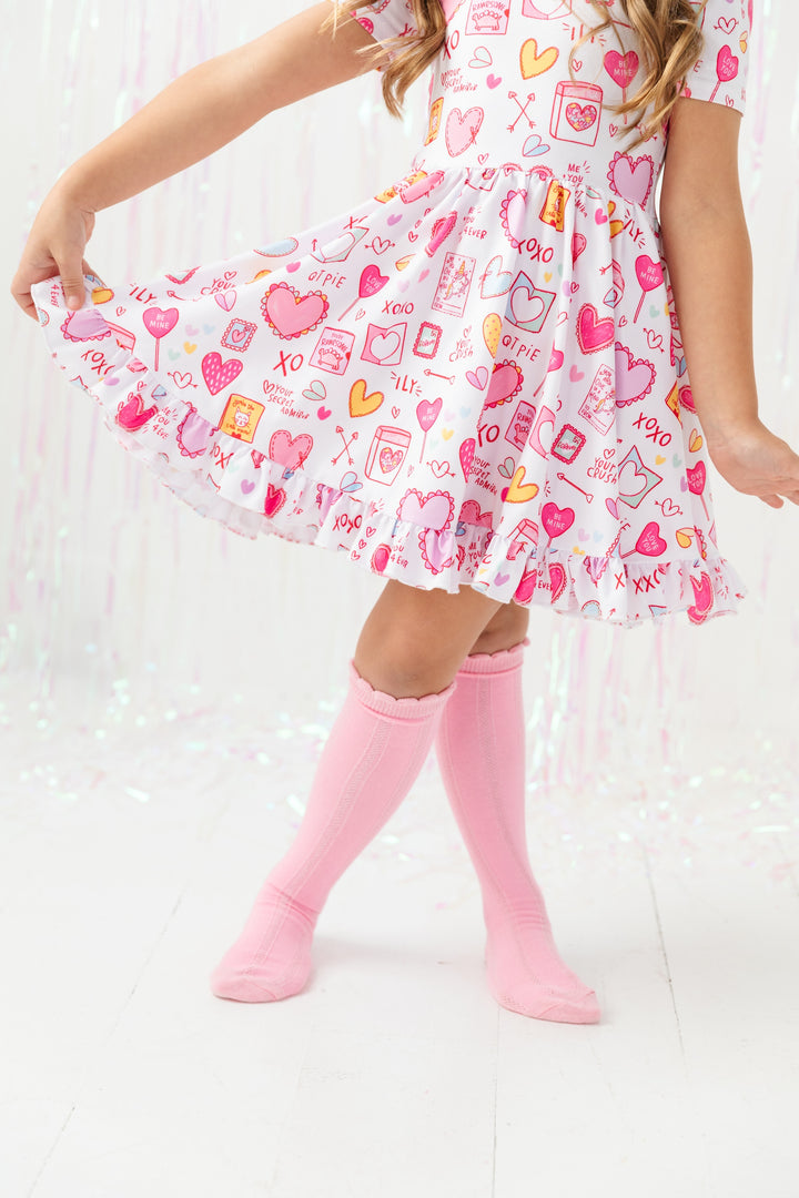 girl posing in Valentine's Day dress and pink scallop knee high socks